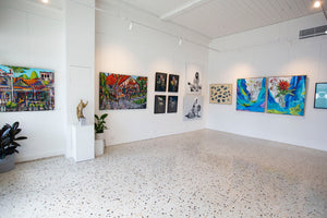Modern art gallery with paintings hanging from a Picture Rail hook system on white walls.
